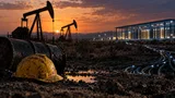 A pair of industrial pump jacks sits idle in a dusty oil field at dusk, their silhouettes dark against a fading orange sky, while in the far distance a cluster of illuminated server racks glows faintly inside a glass-walled data center.