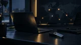 A laptop and hardware wallet sit in a dim security operations setting, symbolizing the separation between digital access and cryptocurrency custody.